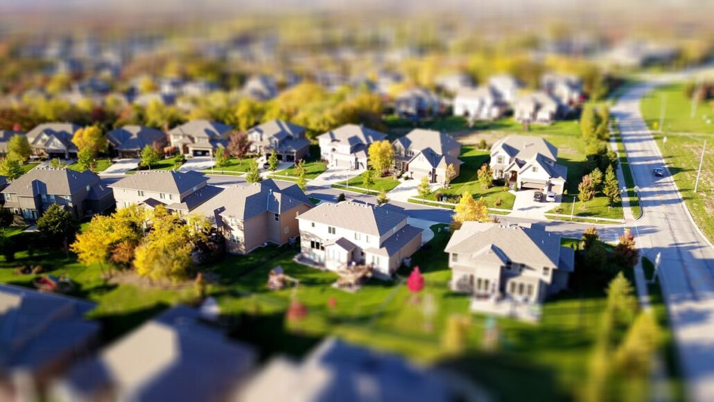 Real estate attorney in a modern, bright office points to a section of a contract while a couple listens intently, feeling...
