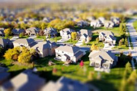 Real estate attorney in a modern, bright office points to a section of a contract while a couple listens intently, feeling...