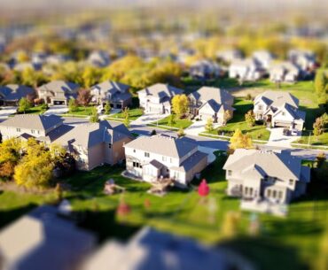 Real estate attorney in a modern, bright office points to a section of a contract while a couple listens intently, feeling...