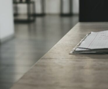Bright, modern desk with neatly laid out architectural blueprints, a laptop, and a cup of coffee, symbolizing the planning...