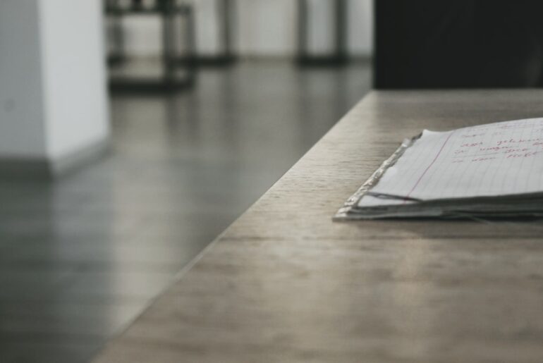 Bright, modern desk with neatly laid out architectural blueprints, a laptop, and a cup of coffee, symbolizing the planning...