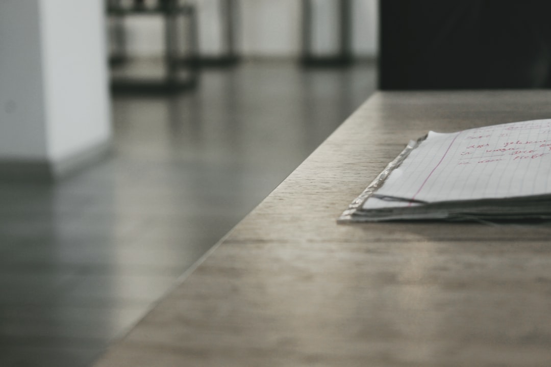 Bright, modern desk with neatly laid out architectural blueprints, a laptop, and a cup of coffee, symbolizing the planning...
