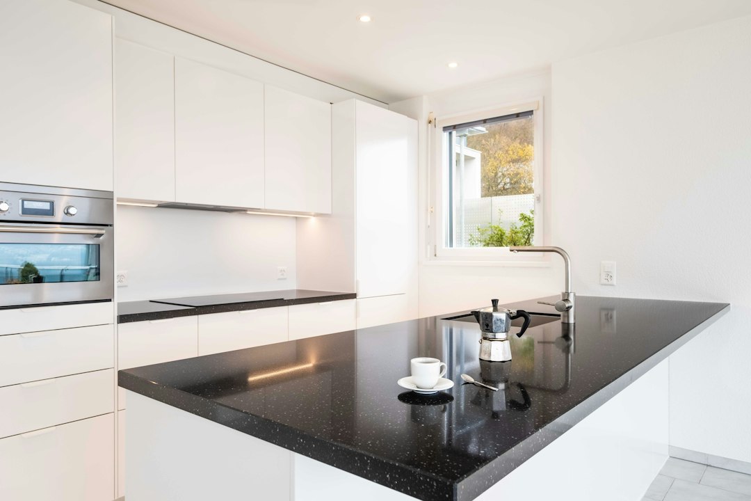 A set of house keys rests on a sleek, modern kitchen counter, signifying a successful and efficient home sale that saves the seller money.
